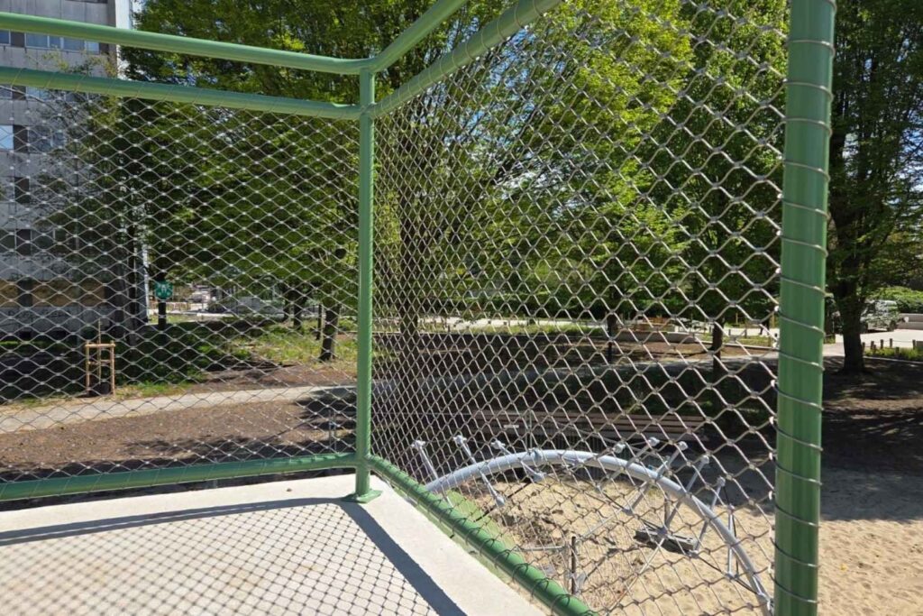 RVS kabelnetten toegepast als veilige en transparante omheining rond de speelzone in het Patrice Lumumbapark