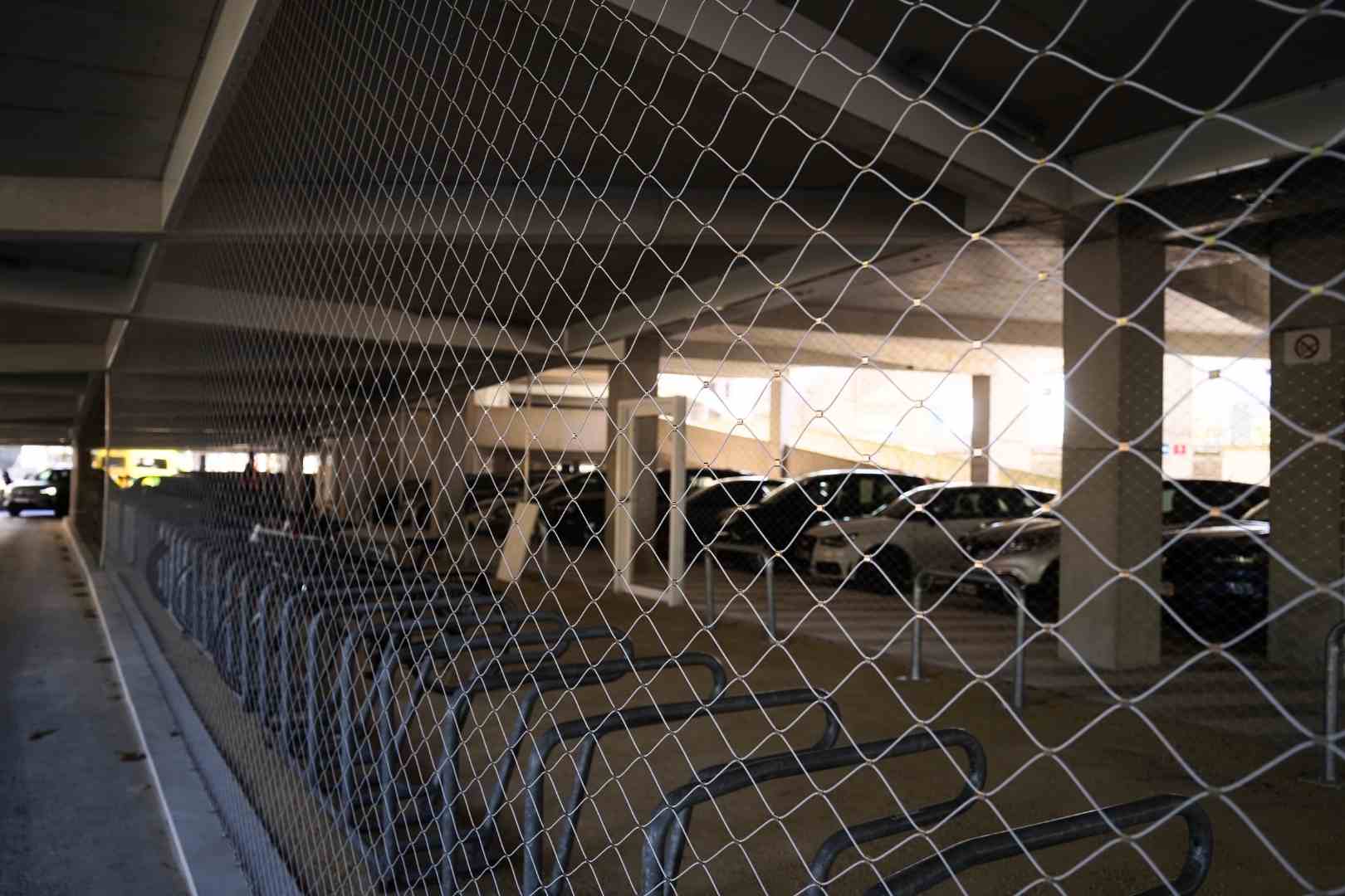 Gecoate RVS kabelnetten als transparante afscherming voor een fietsenstalling en parkeergarage